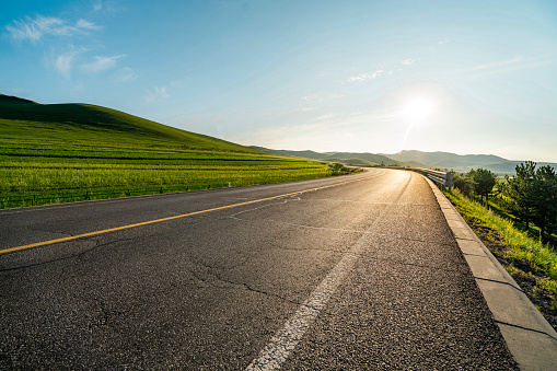 Asphalt road square and green mountain with sky clouds natural background