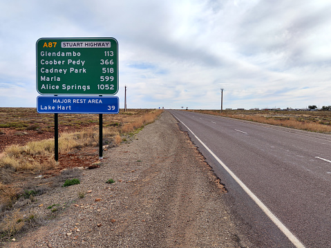 Information sign on the Stuart Highway by the town of Woomera, through the arid lands in South Australia. It is a major Australian highway that runs from Darwin, in the Northern Territory, to Port Augusta in South Australia; a distance of 2,720 km (1,690 mi).