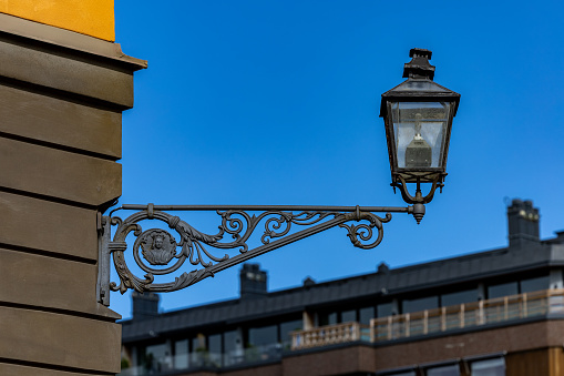 Stockholm, Sweden A classic old wrought iron lamp post on the side of a building in the Ostermalm district.