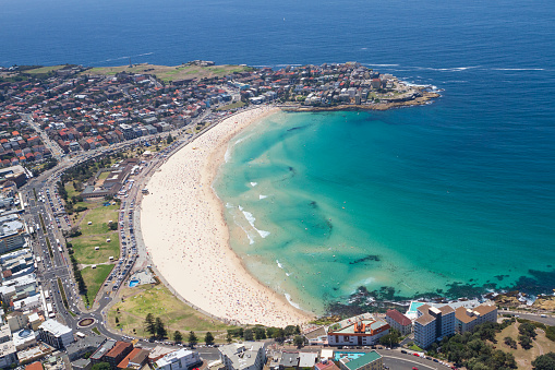 Aerial view of Bondi Beach, Sydney in the peak of a hot Australian summer with the beach packed with people.