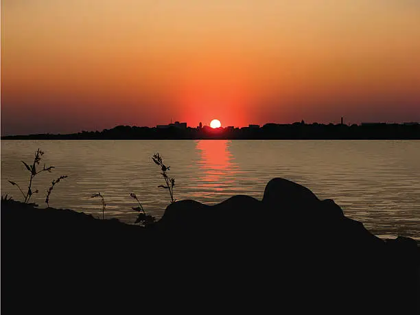 Vector illustration of red sunset over the coastal city