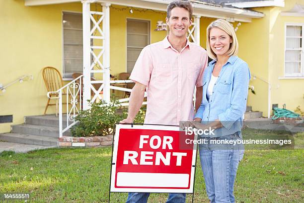 Couple Standing By For Rent Sign Outside Home Stock Photo - Download Image Now - 30-39 Years, Adult, Adults Only