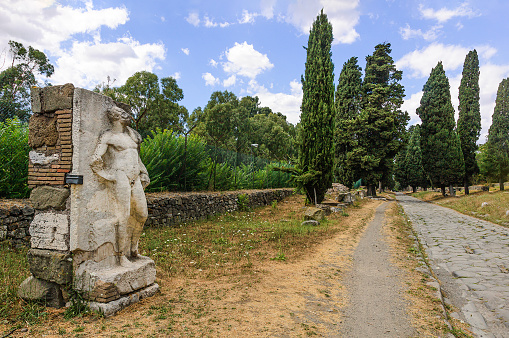 View of the famous Appian Way with a statue of a heroic nude in the foreground