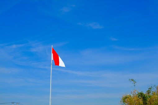Textured Background Photography. Photo Background Indonesian flag waving in the wind on a beautiful landscape. Red and white flag waving on pole. Bandung - Indonesia