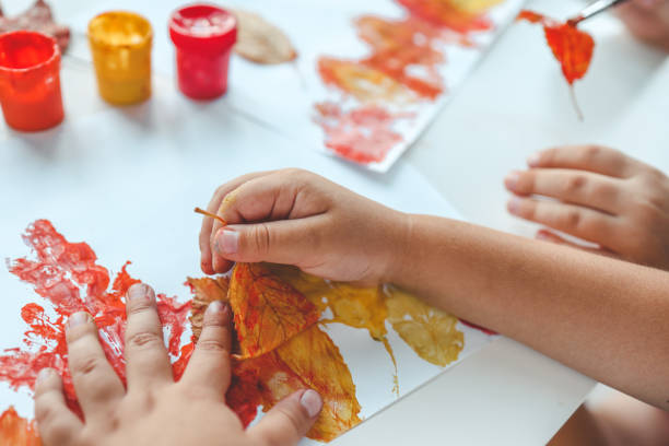 menina pintando em folhas amarelas de outono com guache, artes infantis, criatividade infantil, arte de outono - child autumn craft preschooler - fotografias e filmes do acervo