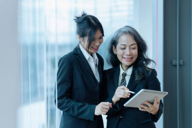 istock Two happy diverse coworker discussing report financial on tablet, working on project together 1645600899