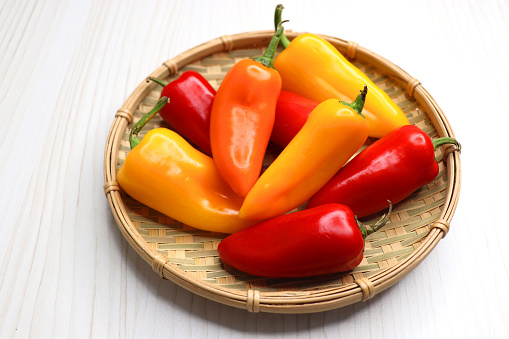 Vibrant chilli peppers. Assorted colorful varieties of hot and sweet peppers or chilies on a farm background. copy space.