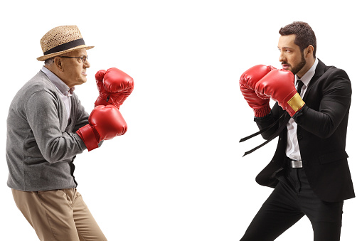 Elderly gentleman and a businessman practicing boxing isolated on white background