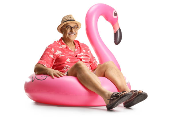 istock Mature man sitting on a big inflatable flamingo rubber ring 1645664292