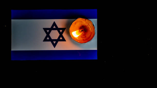 istock Israeli flag and candles burning above it, Holocaust memory day 1645696461