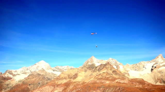 helicopter transporting materials over Matterhorn