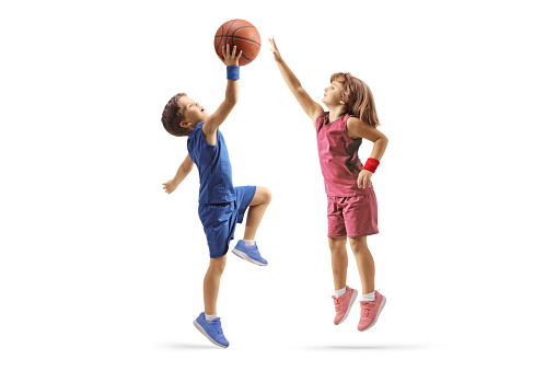 Little boy and girl playing basketball isolated on white background