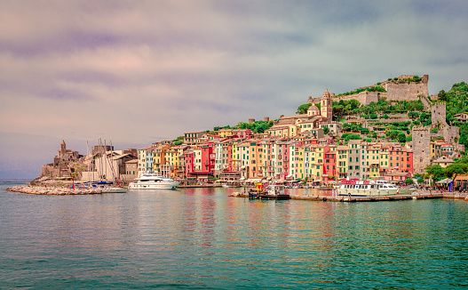 Porto Venere, Italy - May 28 2018: View of the village seen from the sea, with the gothic Church Of San Pietro on the left and Castello Doria on the right. Porto Venere  is a picturesque place on the Ligurian coast, in the province of La Spezia.
