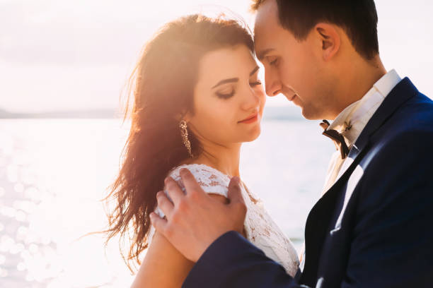 istock Nice couple hugging at the lake on sunset closeup 1645795557