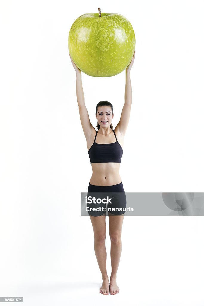 Esbelta mulher em roupas de fitness, segurando uma maçã gigante - Foto de stock de Adulto royalty-free