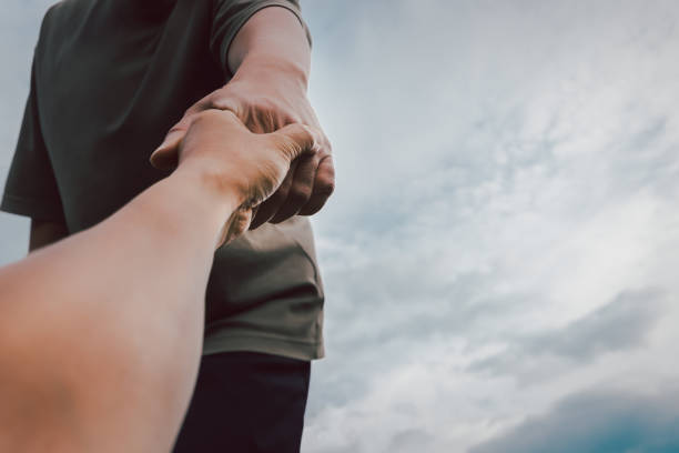 istock Help concept hands reaching out to help each other. 1645824002
