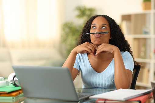 Distracted black student watsing time at home