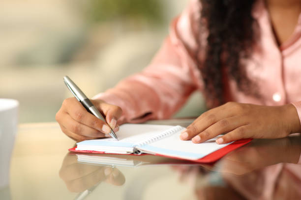 istock Black woman hands writing in agenda 1645836206