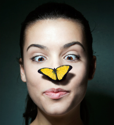 Surprised girl with a butterfly on her nose