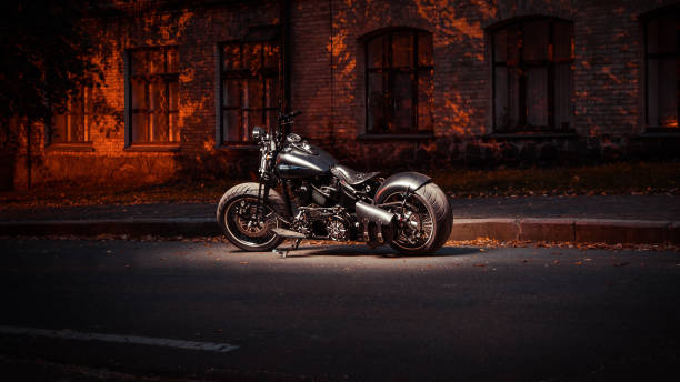 night long exposure shot of custom bike based on Harley-Davidson Fat Boy model Kyiv, Ukraine - September 20 2014: Black motorcycle parked at night near an old building. harley davidson fat boy stock pictures, royalty-free photos & images