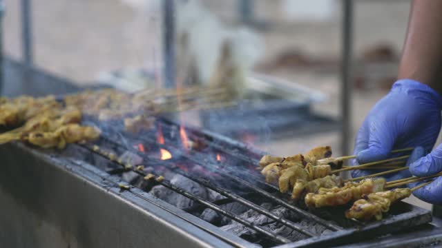Chicken satay on hot charcoal grill, popular street food in Malaysia.