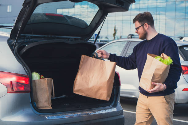 istock happy man put groceries bag in car trunk 1645910626