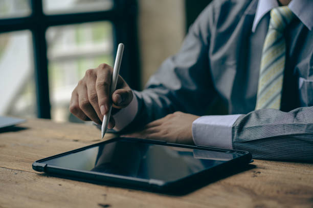 istock The hand holding the pen points to the touchpad tablet running on the device. For technology and business concept, freelance male hand holding stylus and pointing at digital tablet screen 1645942127