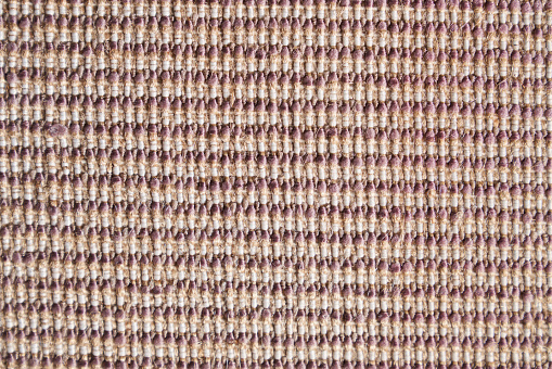 Abstract multicolor textured light grid motif for background. Close up of reverse side of seamless modern woven rug, grunge texture pattern. Concept of textures and backgrounds.