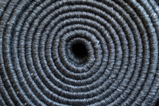 istock Relief texture of rolled up grey textile carpet as background. 1645945092