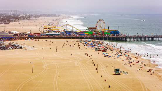 Aerial view of people enjoying at Santa Monica Beach against Santa Monica Pier, Santa Monica, California, USA.
