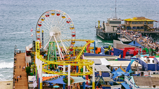 Aerial view of people enjoying at Santa Monica pier against sea, Santa Monica, California, USA.