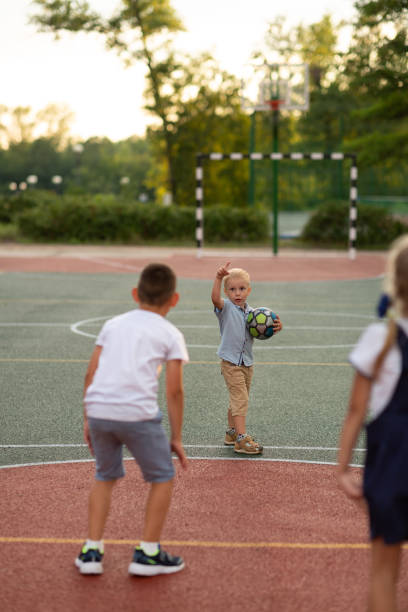 istock Little boy playing ball with friends 1645973279