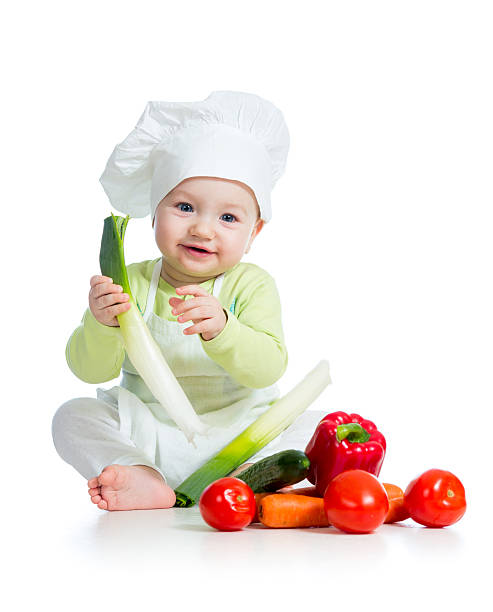 kid boy wearing a chef hat with healthy  food vegetables