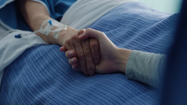 Holding hands, people and support sick cancer patient in hospital bed. Medical wellness, comfort and help person with disease, empathy or kindness in hope of healing for healthcare rehabilitation