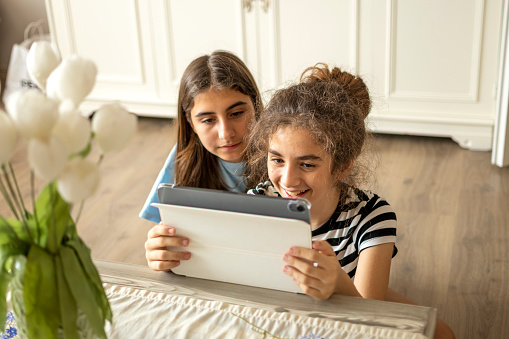 Beautiful teenage girls looking their digital tablet