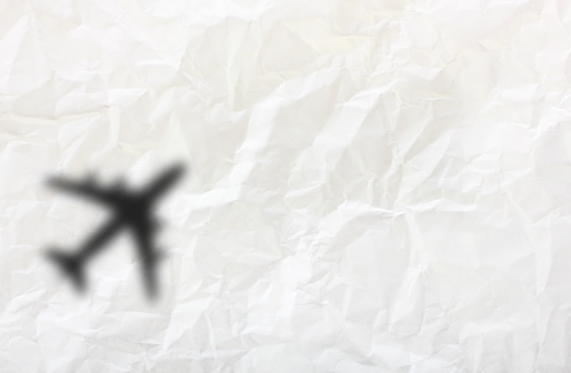 White  Shadow Of Airplane on wrinkled paper background. Concept For Travel, Business Idea, Leadership, Success