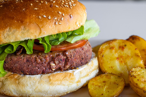 Burger on a plate. Wooden background. Copy space