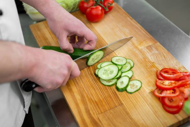 istock Chef in the kitchen cuts fresh and delicious vegetables for a vegetable salad. 1646039773