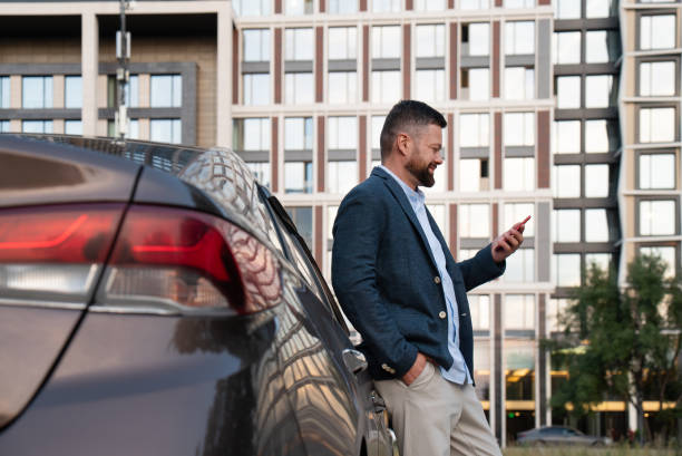 istock Businessman using smartphone near the car 1646045621