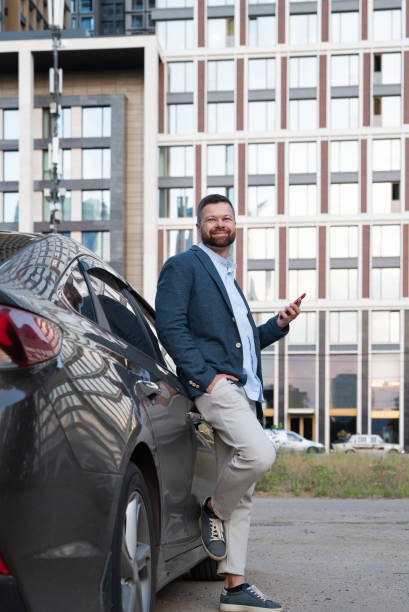 istock Businessman using smartphone near the car 1646045625