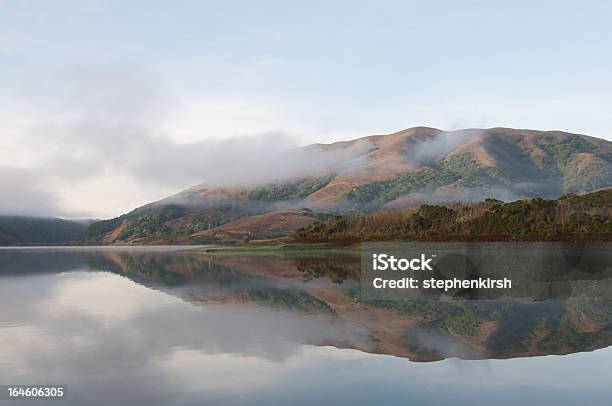 Hills Reflected In Surface Of Lake On A Foggy Morning Stock Photo - Download Image Now