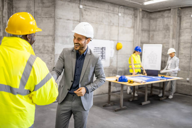 istock Construction industry coworkers shaking hands before new building project starts. 1646068188