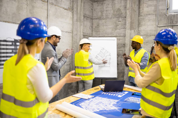 istock Motivated and positive group of structural engineers at construction site meeting laughing and clapping hands. 1646089219