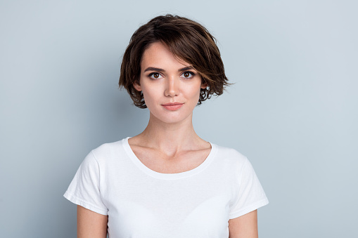 Photo of serious confident woman dressed white t-shirt smiling isolated grey color background.