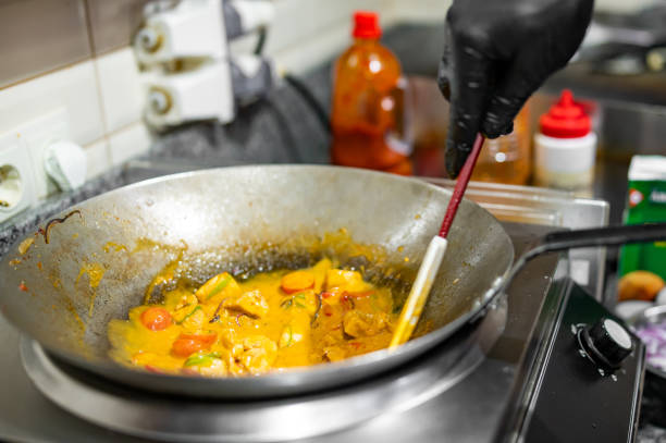istock Professional chef cooking chicken curry food in wok pan on kitchen 1646095105