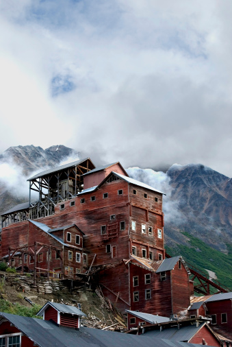 The old historic buildings of Kennecott, Alaska. Misty clouds above and mountains in background.