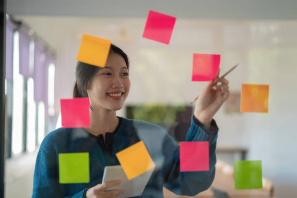 istock Young confident Businesswoman planning with adhesive notes in creative office. 1646097789