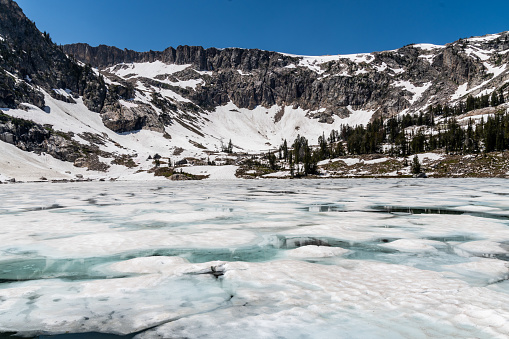 Ice and snow covered Lake Solitude in the Grand Tetons National park in July