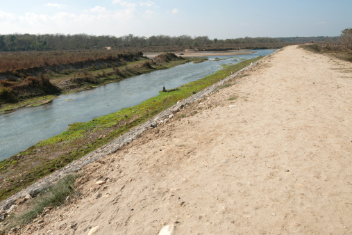 Perspective view of graveled road made alongside the river.