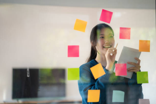 istock Young confident Businesswoman planning with adhesive notes in creative office. 1646114182